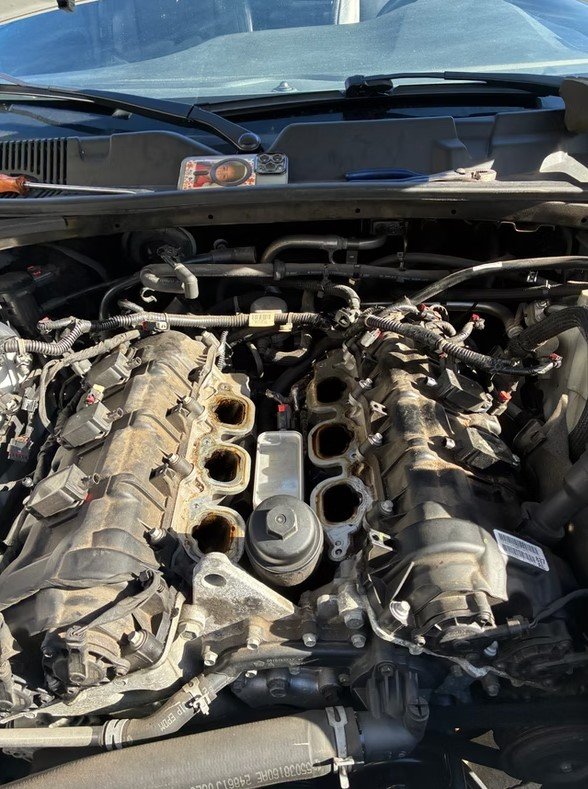 Engine bay repair on a vehicle with the hood open