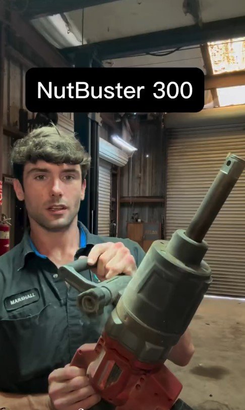 Marshall holding a large impact tool used to remove stuck lug nuts
